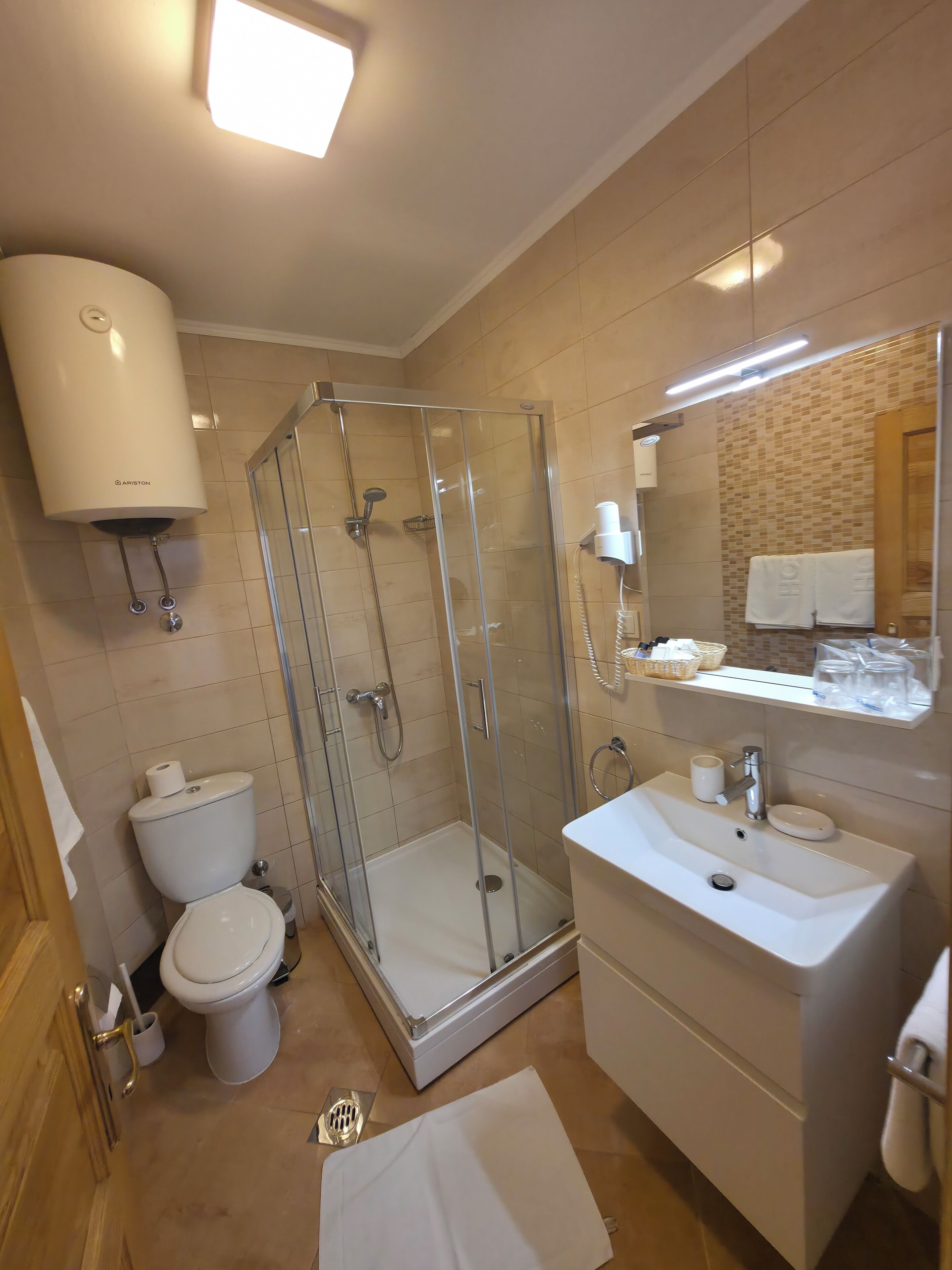 Ein modernes Badezimmer mit einer Duschkabine, Toilette, Waschbecken und Spiegel.