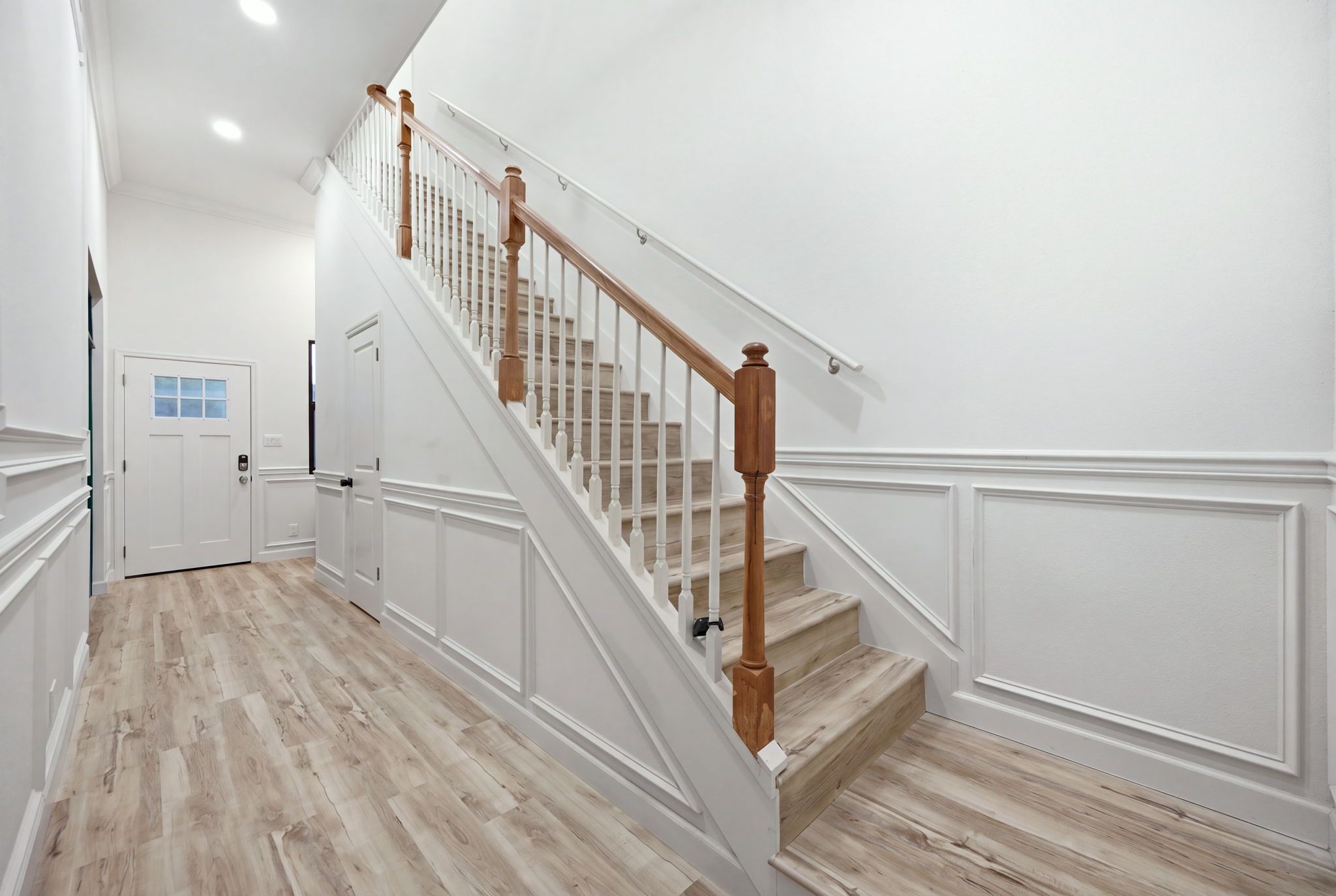 A staircase with wooden balusters and a light-colored wooden floor.