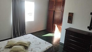 A bedroom with a bed, a dresser, a wardrobe, and a window with curtains. - https://www.airbnb.com.br/hosting/listings/editor/1429156678113976343 (Parque Industrial São José dos Campos)