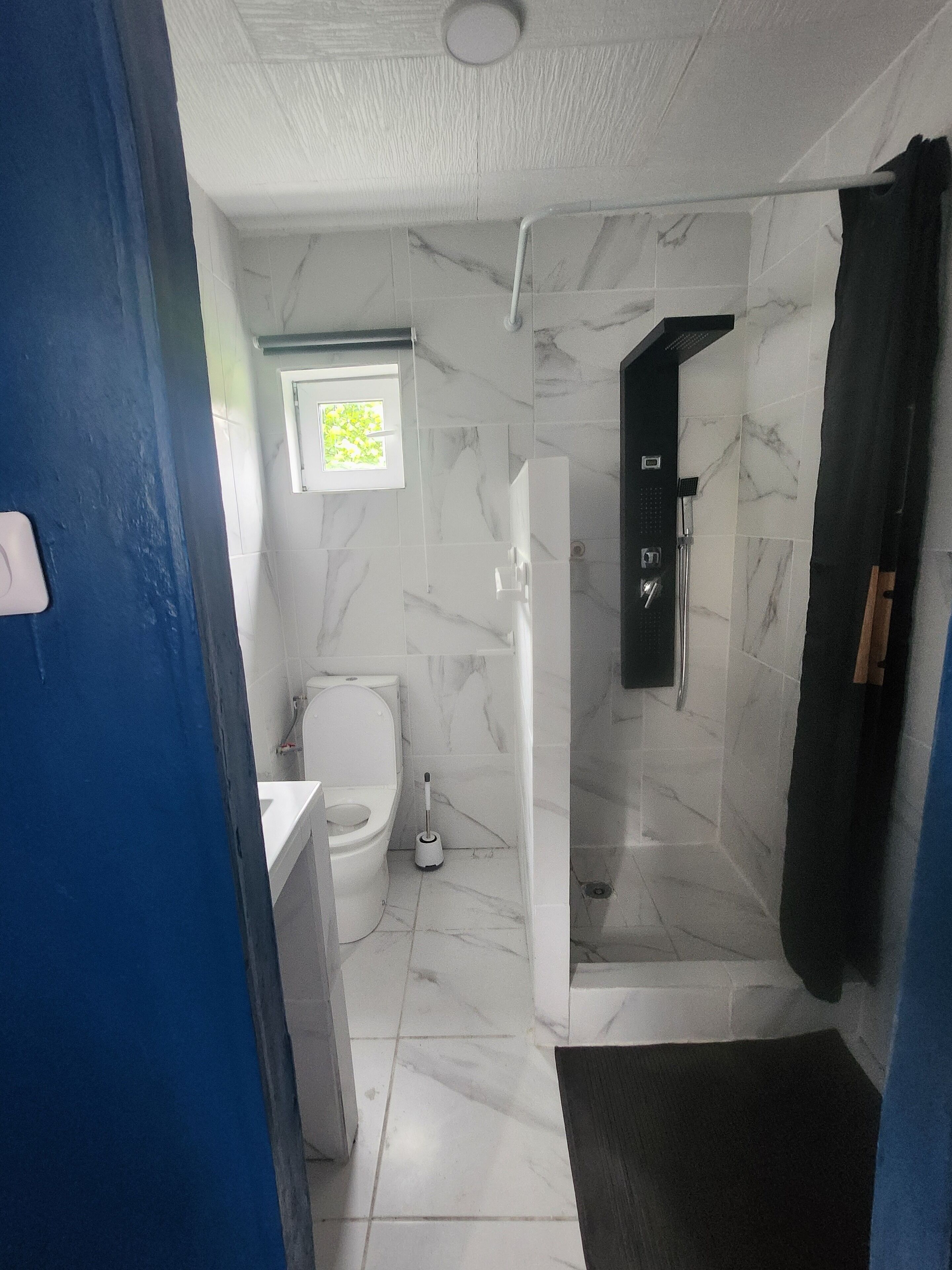 Een douche, handdoeken, zeep, toiletpapier