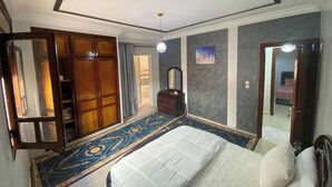 A bedroom with a large bed, a wardrobe, a mirror, and a carpet. - Charming 2-bedroom apartment with WiFi, AC in superb Fès (Fès)