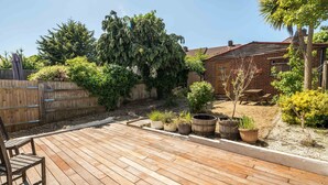 A wooden deck with potted plants and a wooden bench. - Elegant 2Bd House With Garden And Decked Patio (London)