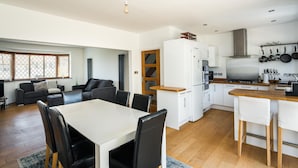 A modern kitchen with white cabinets, a stainless steel refrigerator, and a wooden countertop. - Elegant 2Bd House With Garden And Decked Patio (London)