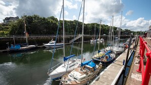 A marina with several boats docked, a wooden pier, and a red railing along the edge. - Historic 2Bd Maisonette In Coastal Eyemouth (Eyemouth)