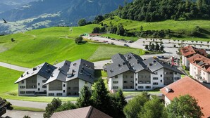 A residential area with modern houses, a road, and a mountainous backdrop. - La Siala Apt.51 by Interhome (Falera)