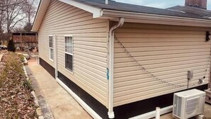 A single-story house with a gabled roof and a side entrance. - Garden Annex (North Garden)