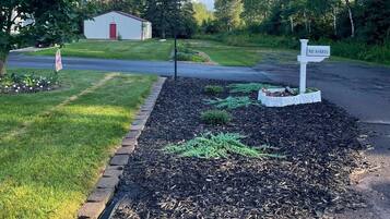 Un quartier résidentiel avec une pelouse, une boîte aux lettres et un petit abri de jardin.