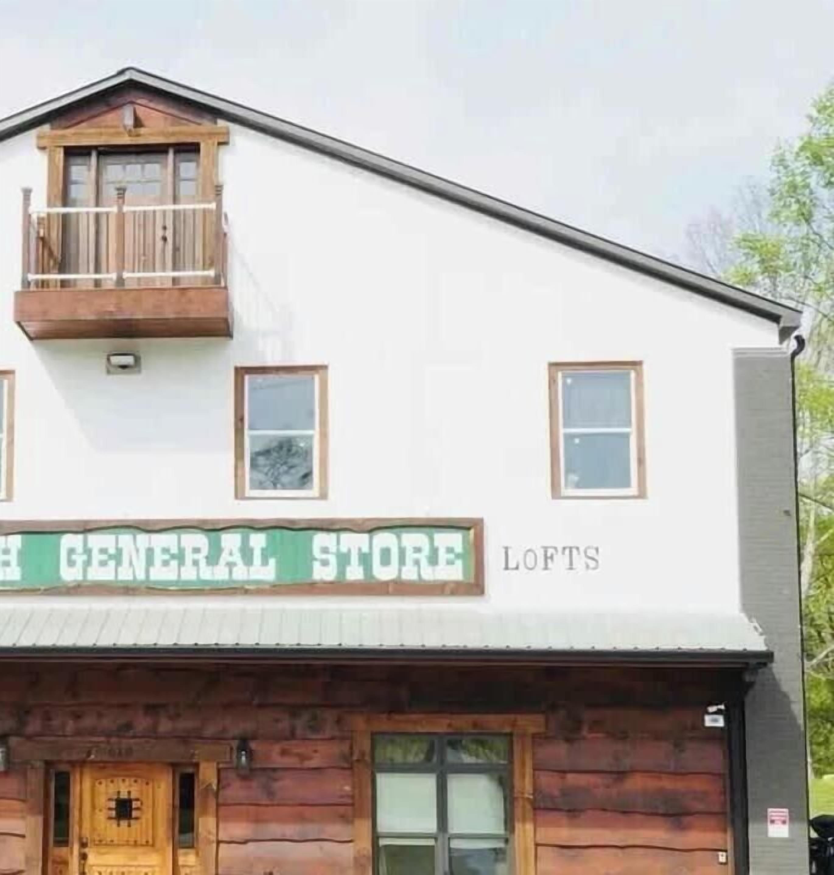 En bygning med et skilt der viser 'H GENERAL STORE' og 'LOFTS', der angiver en butik og lejligheder på loftet.