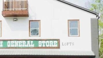 En bygning med et skilt der viser 'H GENERAL STORE' og 'LOFTS', der angiver en butik og lejligheder på loftet.