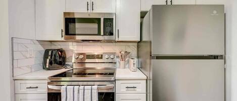 Coffee/tea maker, fridge, cookware/dishes/utensils