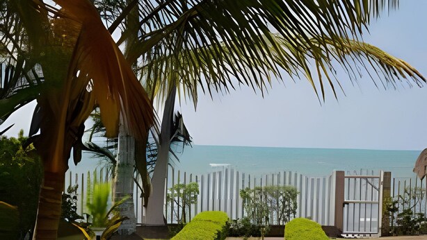 A pathway leading to a beach with palm trees and a fence. - Tu casa de playa frente al mar en Tolú (Tolú)