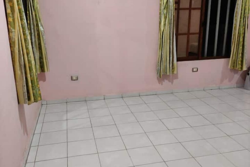 A room with a tiled floor and pink walls.