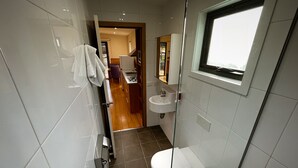 Une salle de bain moderne avec des toilettes, un lavabo et une fenêtre.