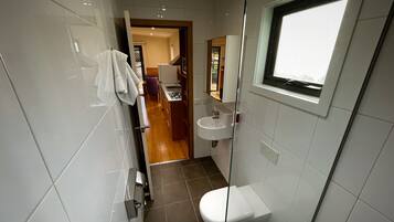 A modern bathroom with a toilet, sink, and a window.