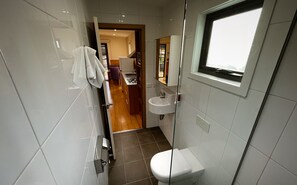 Un baño moderno con inodoro, lavamanos y ventana.