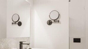 A modern bathroom with a white vanity, a round mirror, and a shower area. - Elegant room with private bathroom in historic house - city center (Brugge)