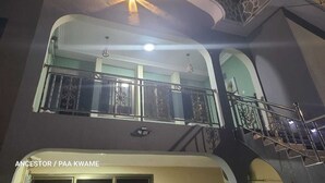 Un edificio de varios niveles con un balcón, una escalera y un lámpara con forma de estrella.