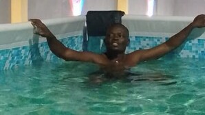Una persona en una piscina con los brazos extendidos.