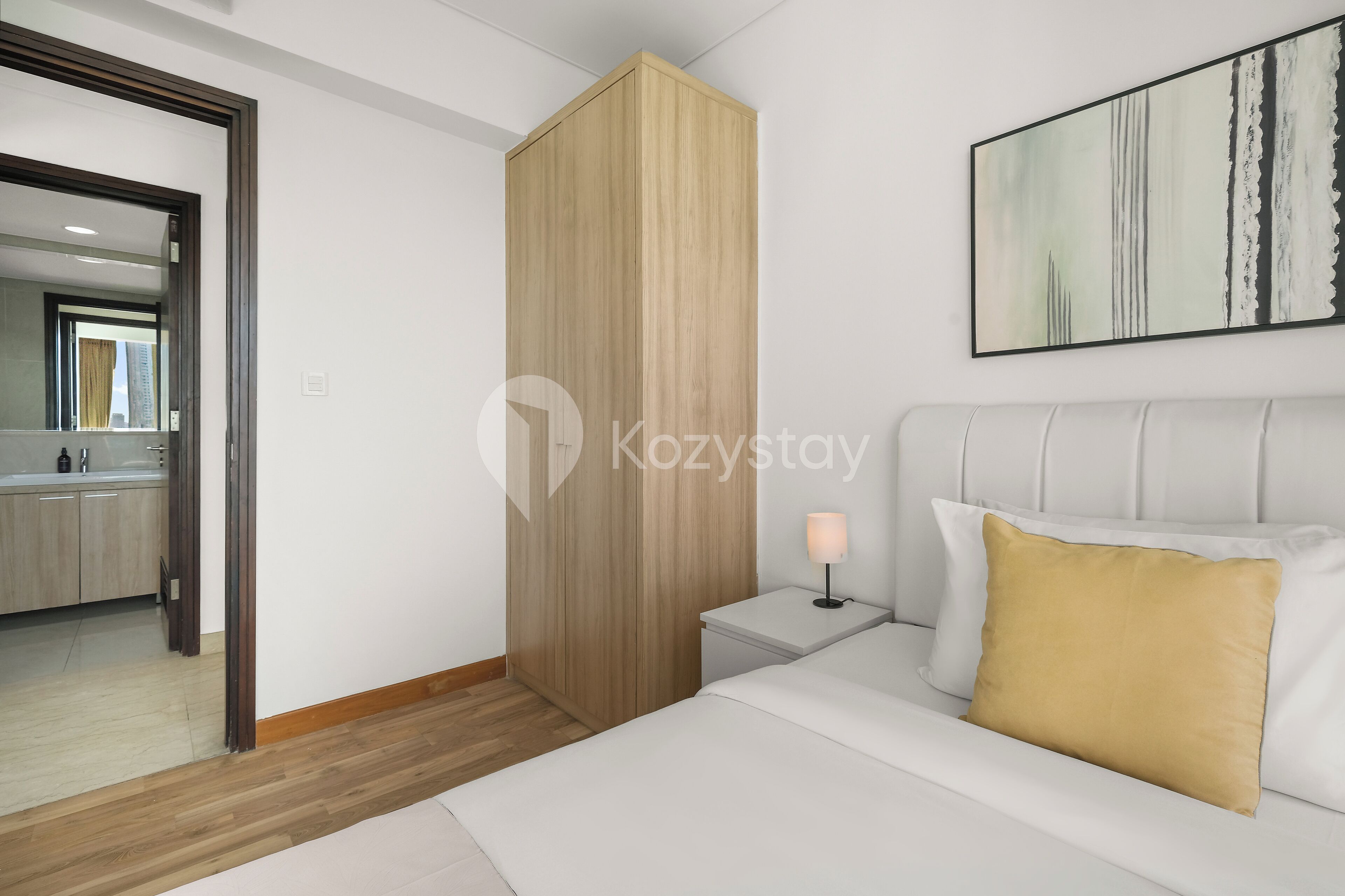 Een moderne slaapkamer met een bed, nachtkastje en een bedtafel met een lamp.