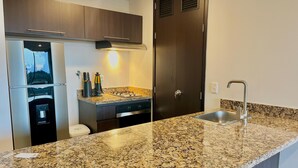 Una cocina moderna con encimeras de granito, electrodomésticos de acero inoxidable y armarios de madera.