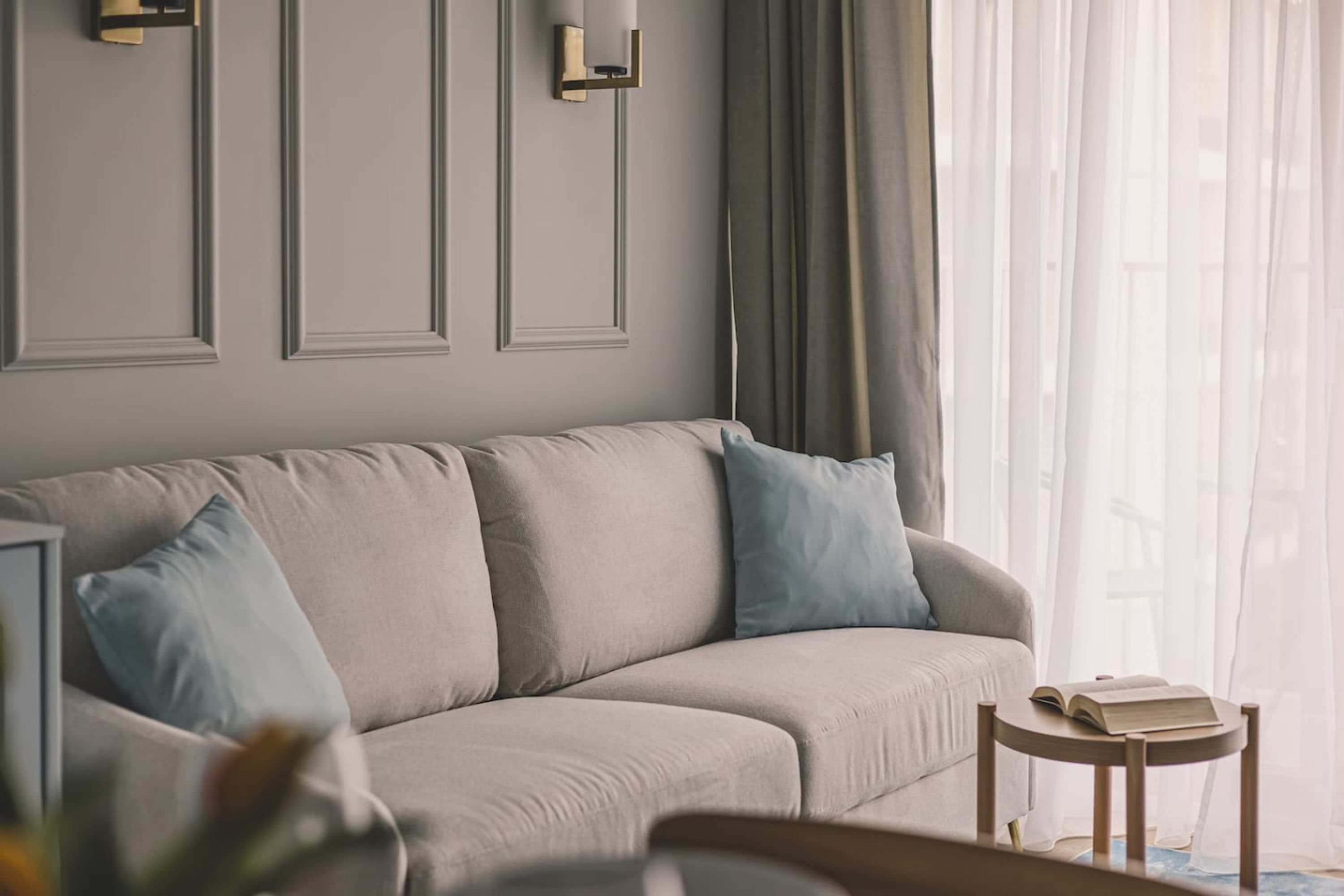 A living room with a sofa, a small round table, and a book on the table.