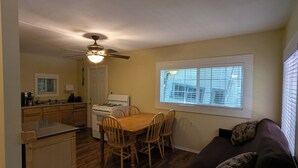 A compact kitchen with a dining area, a ceiling fan, and a window with blinds. - Perfect home base for all things "Redwoods"! Space to park boat. Dog friendly. (Klamath)