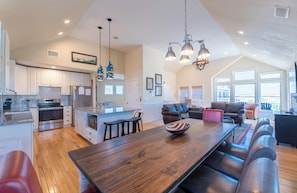 A spacious kitchen with a large island, modern appliances, and pendant lighting. - Patriot's Place - Corolla, Ocean Sands, 180 Yds to Beach, Pool, Hot Tub, Pool Table, Pets OK (Corolla)
