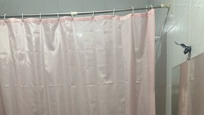 A bathroom with a shower curtain, a sink, and a toilet.