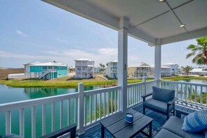 A covered outdoor area with a view of a body of water and buildings in the background. - Shared Pool, Shared Hot tub, Pet Friendly, Boardwalk to the Beach (Port Aransas)