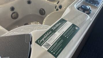 Un jacuzzi con un código QR y un cartel.