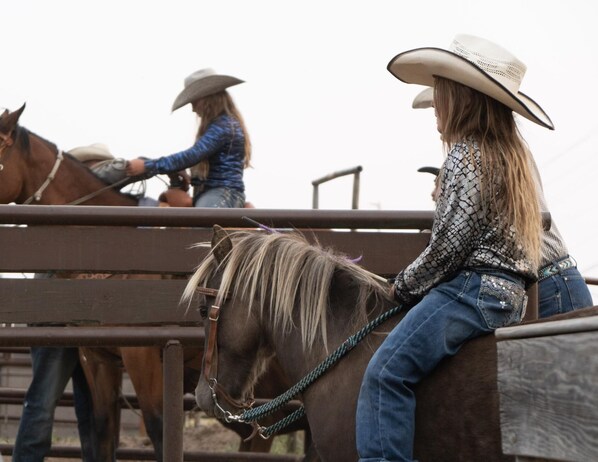 A person riding a horse in an outdoor arena. - The Skyles Lake Escape- A cozy mountain retreat! (Whitefish)