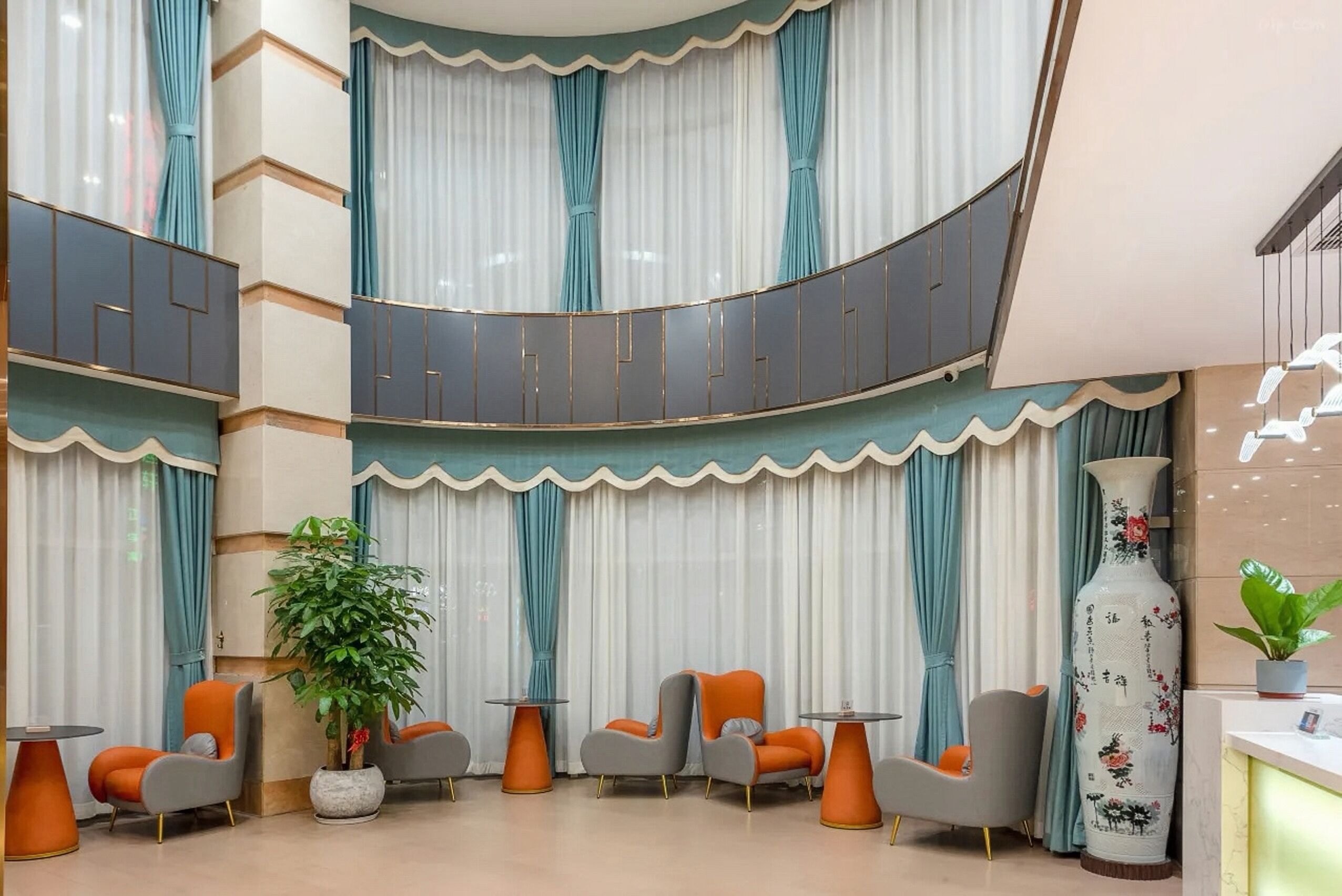 A lobby with tiered seating, a large vase, and a potted plant.