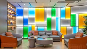 Un espace de détente moderne comprenant un canapé d’angle, une table basse et une bibliothèque.
