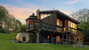 A large, multi-story wooden house with a balcony and a barrel. - White Mtn Lux Retreat - Hot Tub, Sauna & Game Room (Bartlett)