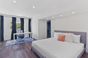 Ein modernes Schlafzimmer mit einem großen Bett, einem Schreibtisch und einem Stuhl.
