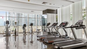 Uma academia com esteiras, elípticos e bicicletas ergométricas.