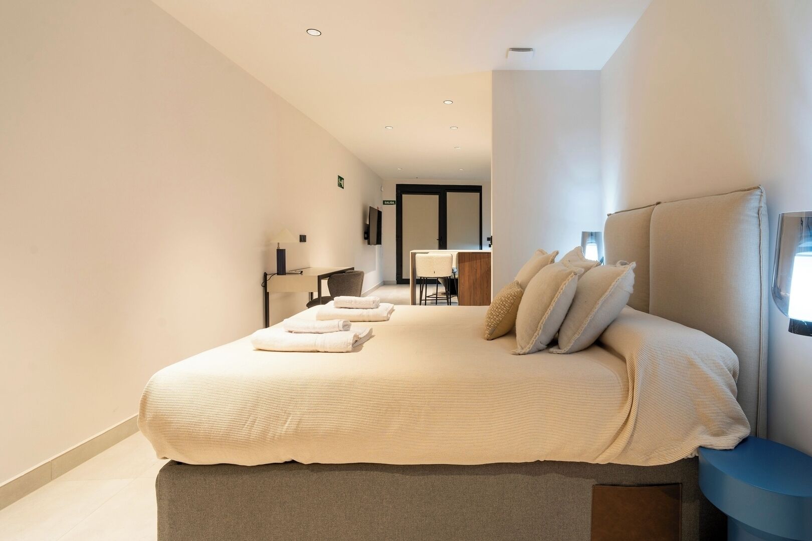 Une chambre d’hôtel moderne avec un grand lit, une table de chevet et un téléviseur.