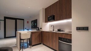 Une cuisine moderne avec des meubles en bois, un four à micro-ondes encastré, un évier et une cuisinière.