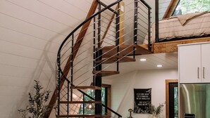 Ein modernes Loft mit Wendeltreppe, Holzbalken, einer Küche und einer gemütlichen Sitzecke.