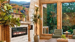Un interior moderno con chimenea, ventanas amplias y un mobiliario cómodo.
