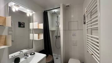 Een douche, een haardroger, handdoeken, toiletpapier