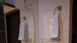A bathroom with a white sink, a mirror, a towel rack, and a trash bin. - Mawed Al Dyafa Serviced Apartments  (Riyadh)