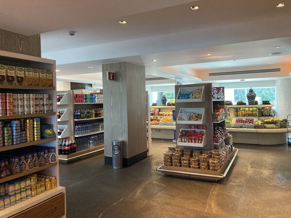 A grocery store interior with shelves stocked with canned goods, beverages, and packaged foods.