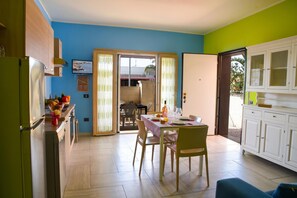 A kitchen with a dining table, chairs, and cabinets.