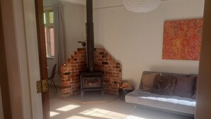 Una sala de estar con chimenea de ladrillo, un sofá y una alfombra.