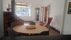 Un comedor con una mesa redonda, sillas y una lámpara colgante.