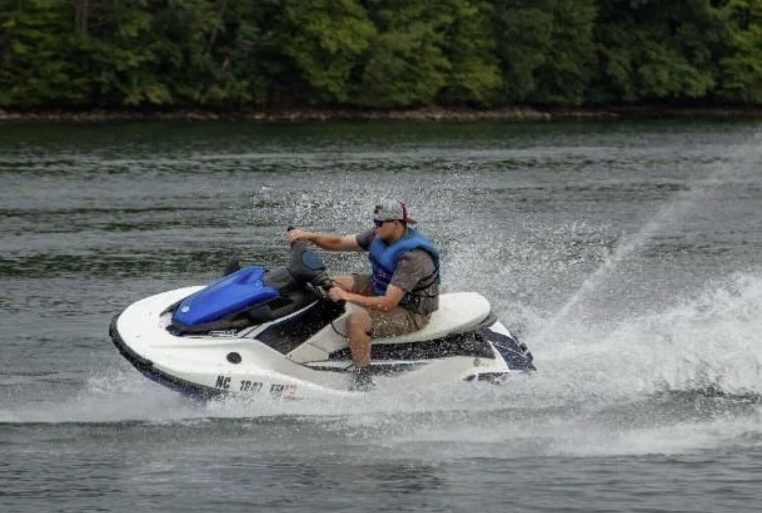 Une personne conduisant un jet ski sur une étendue d’eau.