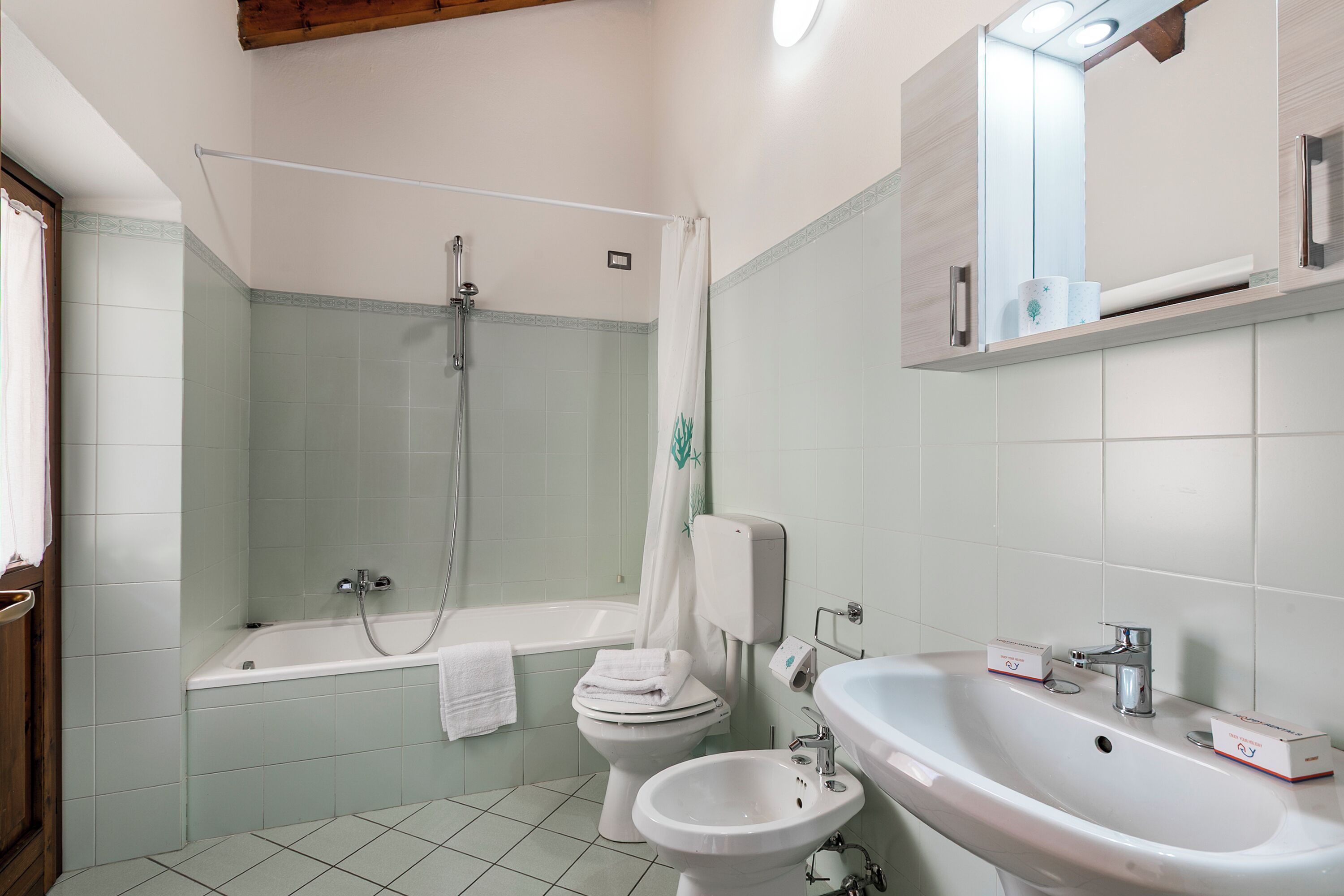 Une salle de bain équipée d’une baignoire, de toilettes, d’un bidet et d’un lavabo.