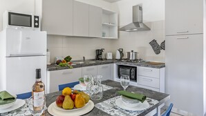 A modern kitchen with white cabinets, a built-in microwave, and a gas stove. - Nel Cuore Di Baveno Apartment, 50m from Lake, Baveno, Italy (Baveno)