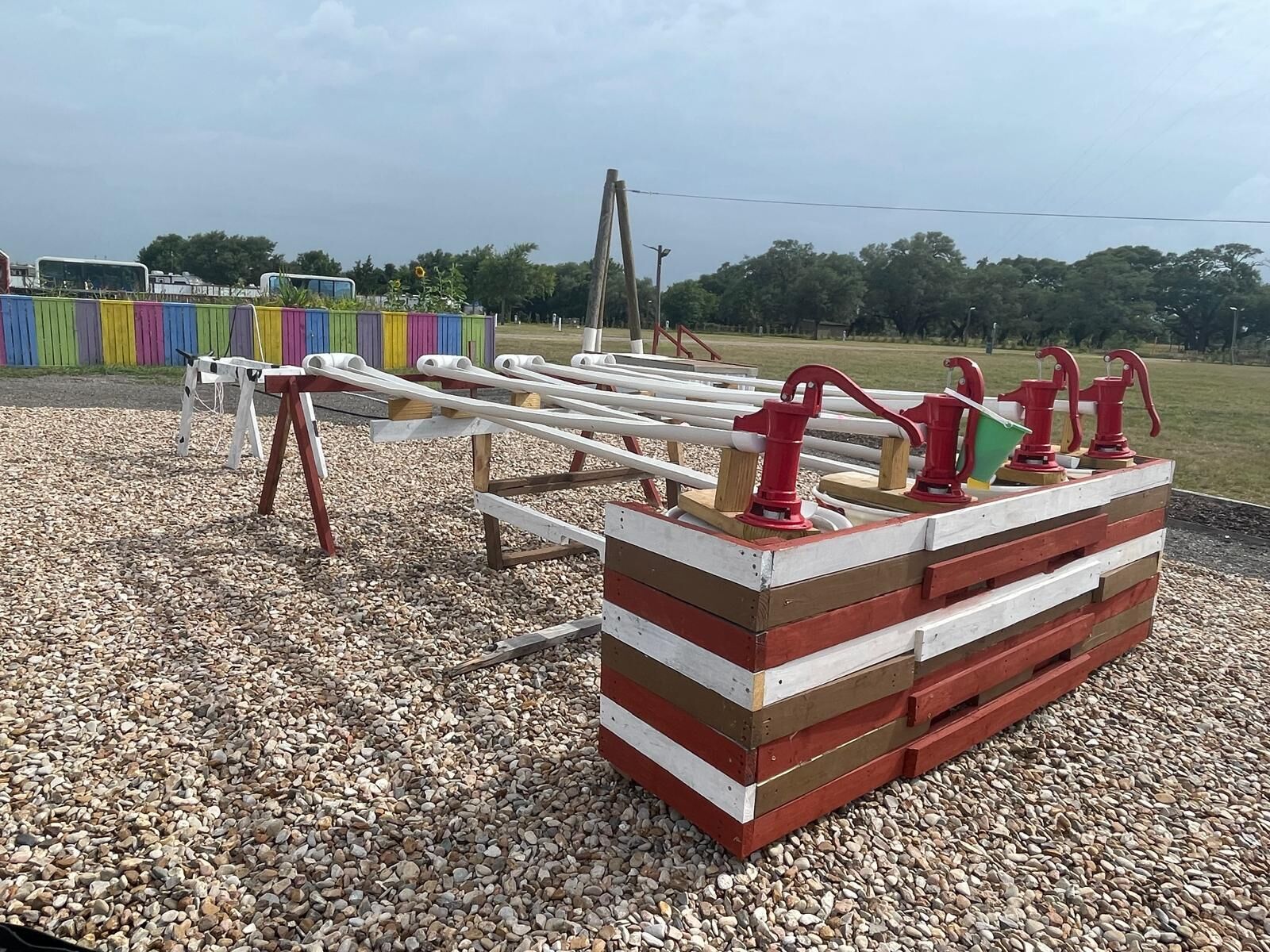 A playground with a seesaw and red and white play structures.